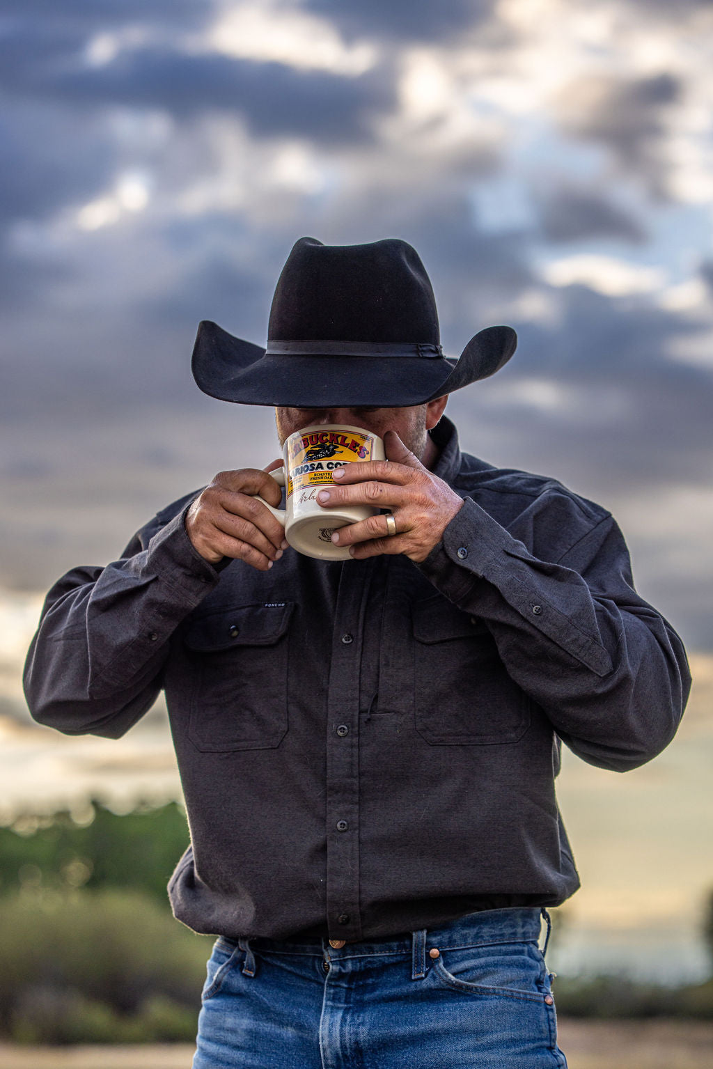 A rancher drinking Arbuckle's coffee from an Ariosa mug